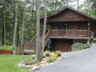 a log cabin with a deck and a porch at Creekside Log Cabin Rental with Kayaks in Saugerties, New York in Saugerties