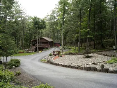 a winding road leading to a cabin in the woods at Creekside Log Cabin Rental with Kayaks in Saugerties, New York in Saugerties