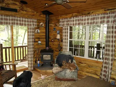 a living room with a fireplace in a log cabin at Creekside Log Cabin Rental with Kayaks in Saugerties, New York in Saugerties