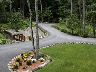 a winding road with flowers in a garden at Creekside Log Cabin Rental with Kayaks in Saugerties, New York in Saugerties