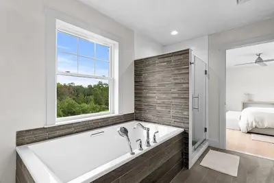 a bathroom with a tub and a window and a bed at Elevated Catskills Getaway On 15-acre Private Farm in Parksville