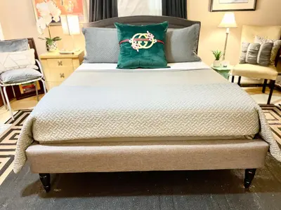 a large bed with a green pillow on it at Welcome to Grande Lux - Boutique Hotel Style- 20 mins to NYC Times Square in Englewood