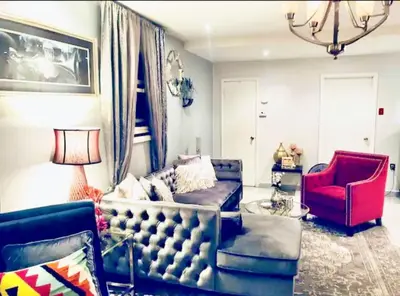 a living room with a couch and a red chair at Welcome to Grande Lux - Boutique Hotel Style- 20 mins to NYC Times Square in Englewood