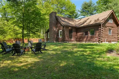 a log cabin with a table and chairs in the yard at The Bears Nest in Boiceville