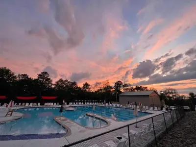 a large swimming pool with a sunset in the background at Masthope Heritage Chalet in Lackawaxen
