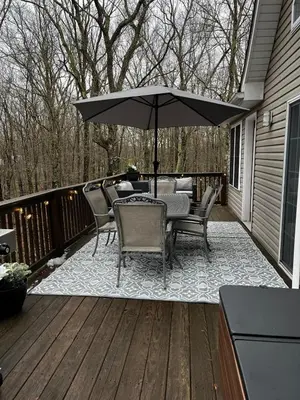 a patio with a table and chairs and an umbrella at Masthope Heritage Chalet in Lackawaxen