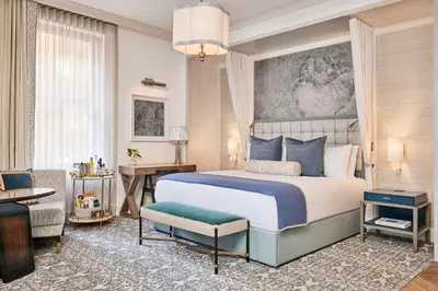 a bedroom with a king sized bed and a living room at The Wall Street Hotel by Suiteness in New York