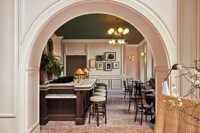 an archway leading to a bar in a restaurant at The Wall Street Hotel by Suiteness in New York