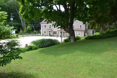 a house with a tree in the middle of a yard at Cornwall Inn in Cornwall Bridge