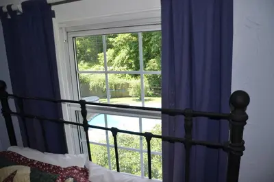 a bedroom with a bed and a window with blue curtains at Cornwall Inn in Cornwall Bridge