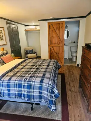 a bedroom with a bed and a sliding barn door at Cornwall Inn in Cornwall Bridge
