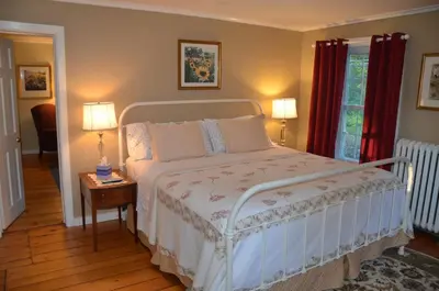 a bedroom with a white bed with two lamps and a table at Cornwall Inn in Cornwall Bridge