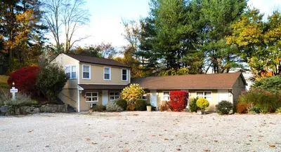 a house with a driveway in front of it at Cornwall Inn in Cornwall Bridge