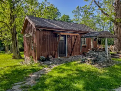 a small cabin with a porch in the grass at Cozy Cabin Gateway with Pool and Firepit in Montgomery