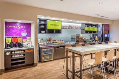 a coffee shop with a table and chairs in a store at Home2 Suites by Hilton Albany Airport/Wolf Rd in Albany