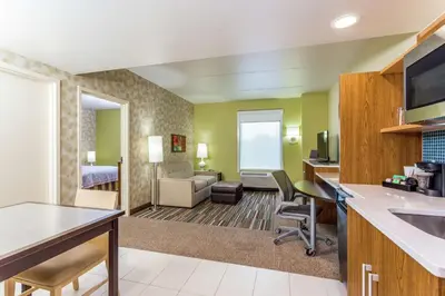 a hotel room with a kitchen and a living room at Home2 Suites by Hilton Albany Airport/Wolf Rd in Albany