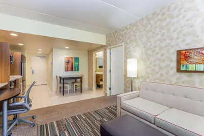 a living room with a couch and a dining room at Home2 Suites by Hilton Albany Airport/Wolf Rd in Albany