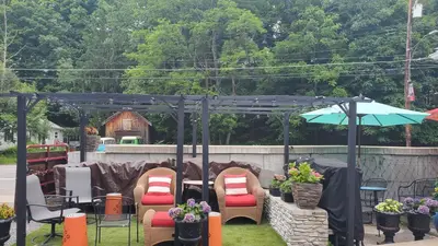 a group of chairs and an umbrella in a yard at The Empire House Hotel and Restaurant in Gilbertsville