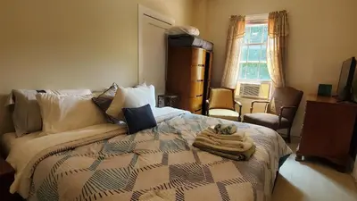 a bedroom with a bed and a couch and a window at The Empire House Hotel and Restaurant in Gilbertsville