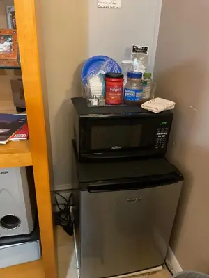 a black microwave in a corner of a room at Grande Lux Room- Boutique Hotel Style-15mins to NYC in Englewood