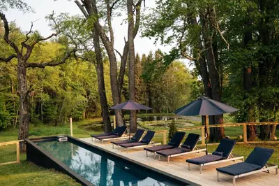a group of chairs and umbrellas next to a pool at Coop 002 in Kenoza Lake