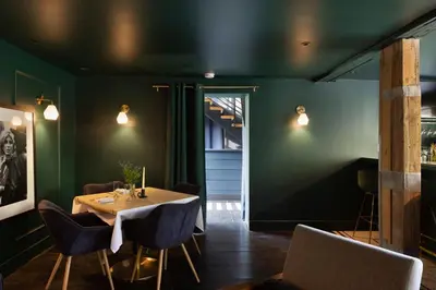 a dining room with green walls and a table and chairs at Coop 002 in Kenoza Lake