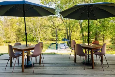 two tables and chairs with umbrellas in a park at Coop 002 in Kenoza Lake