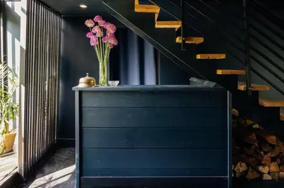 a vase of pink flowers on a table next to a staircase at Coop 003 in Kenoza Lake