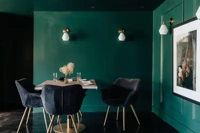 a dining room with green walls and a table with chairs at Coop 004 in Kenoza Lake