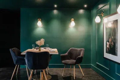 a dining room with a table with chairs and green walls at Coop 004 in Kenoza Lake