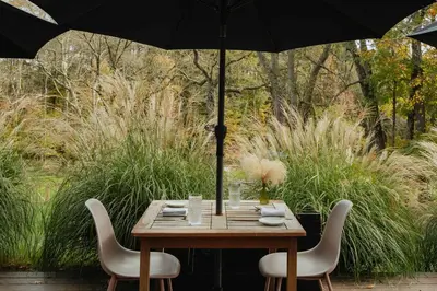 a wooden table with two chairs and an umbrella at Suite 001 in Kenoza Lake