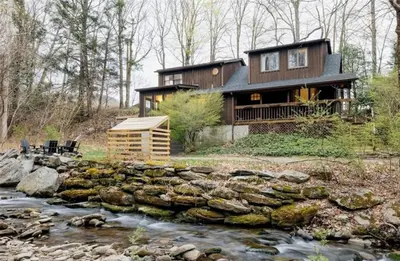 a house on a hill next to a stream at Catskills ChestnutCreek+Swimming Hole+Firepit+Hike in Neversink