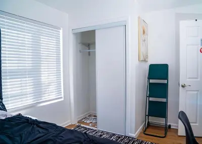 a bedroom with a window and a door with a chair at Anike's Place in Newark