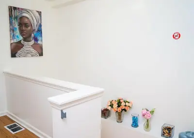 a painting of a woman on a wall with vases at Anike's Place in Newark
