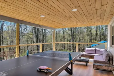 a screened in porch with a ping pong table at Charming Retreat Walking in Tannersville