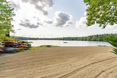 a sandy beach next to a lake with boats at Cozy Berkshires Cabin with Lake, Beach, Hot Tub, Fireplace - The Wilde BNB