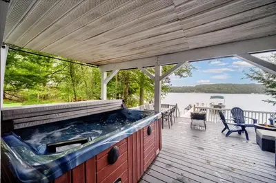 an outdoor kitchen on a deck with a view of a lake at Catskills Lakefront with Hot Tub, Sauna and Theater in Monticello