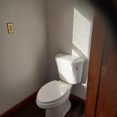 a bathroom with a white toilet and a window at The Lordship Loft in Stratford