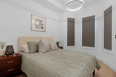 a bedroom with a bed and two windows at Luxury Duplex in Hoboken 15Min to NYC, Fire Pit in Jersey City