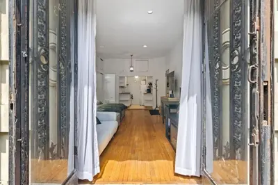 a hallway leading to a living room with white curtains at Stylish Studio in Central Park Best Location Ever in New York