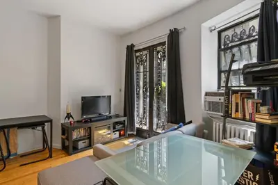 a living room with a glass table and a tv at Stylish Studio in Central Park Best Location Ever in New York