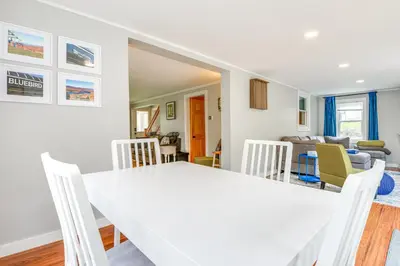 a dining room and living room with a white table and chairs at 2 Mi to Mt Snow Cozy Family Alpine Retreat! in Wardsboro