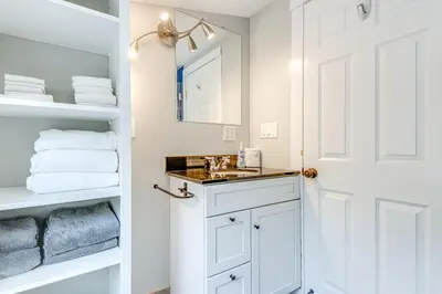 a white bathroom with a sink and towels at 2 Mi to Mt Snow Cozy Family Alpine Retreat! in Wardsboro