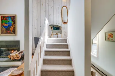 a staircase in a home with a fireplace at Ski, Hike and More Year-Round Gem in Windham in Windham