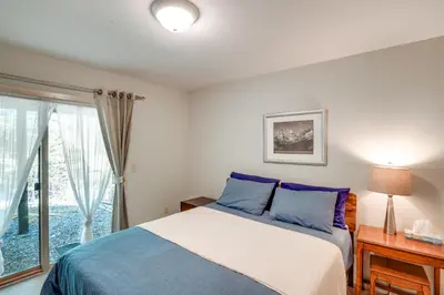 a bedroom with a bed with blue pillows and a window at Ski, Hike and More Year-Round Gem in Windham in Windham