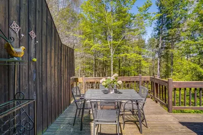 a wooden deck with a table and chairs on it at Ski, Hike and More Year-Round Gem in Windham in Windham