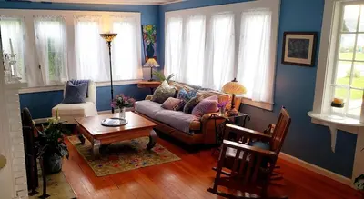 a living room with a couch and a table at Enchanted Cottage 1 block to beach in Madison