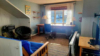 a room with a bed and a desk and a window at Enchanted Cottage 1 block to beach in Madison