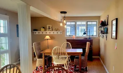 a dining room with a table and chairs at Enchanted Cottage 1 block to beach in Madison