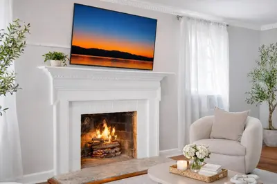 a living room with a fireplace with a television above it at New Haven Staycation Near Yale Washer and Dryer Groups in New Haven